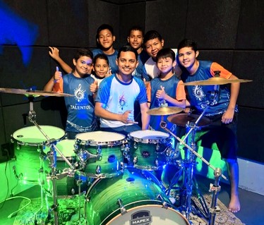 Alunos e instrutor na aula de bateria